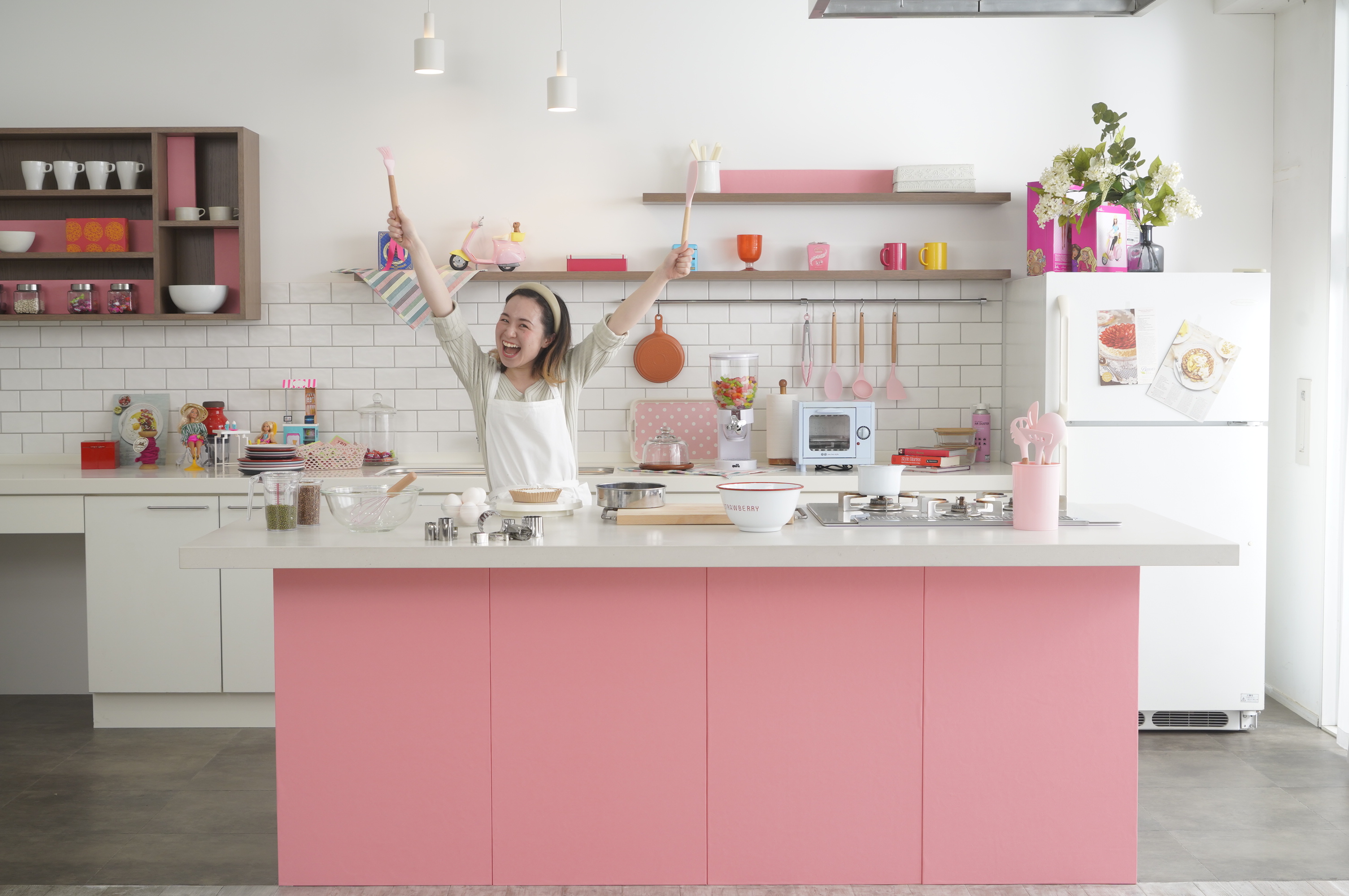ピンクのキッチンで笑顔の若い女性